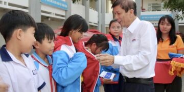 Nhà báo Nguyễn Khắc Văn, Quyền Tổng Biên tập Báo SGGP, trao áo ấm cùng học bổng đến các em học sinh tại xã Bình Lợi.