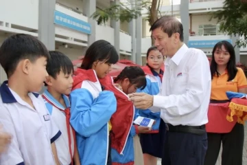 Nhà báo Nguyễn Khắc Văn, Quyền Tổng Biên tập Báo SGGP, trao áo ấm cùng học bổng đến các em học sinh tại xã Bình Lợi.